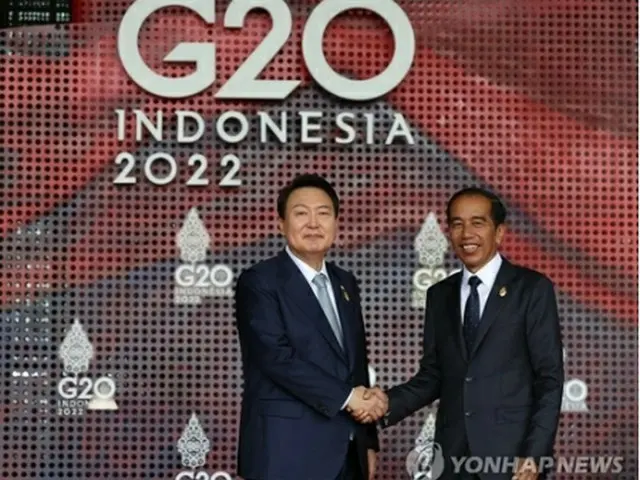 主要２０カ国・地域首脳会議（Ｇ２０サミット）の議長を務めるインドネシアのジョコ大統領（右）と握手する尹大統領＝１５日、バリ島（聯合ニュース）