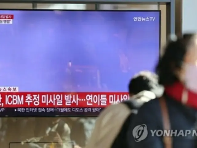 ソウル駅のテレビで北朝鮮のミサイル発射のニュースを見る人たち＝１８日、ソウル（聯合ニュース）