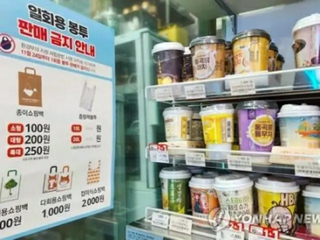 ソウル市内のコンビニ。レジ袋配布の禁止と、代わりに提供できる有料バッグの案内が掲示されている＝２２日、ソウル（聯合ニュース）