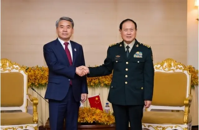握手する李鐘燮長官（左）と魏鳳和国務委員兼国防相（国防部提供）＝（聯合ニュース）≪転載・転用禁止≫