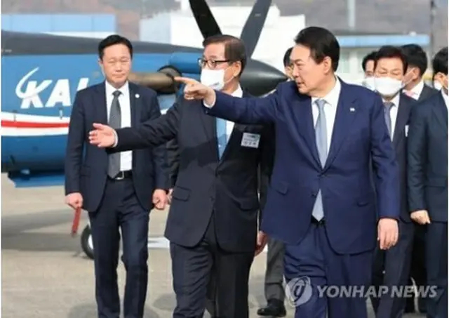 韓国航空宇宙産業を訪れ、展示されている戦闘機などを視察する尹大統領（手前）＝24日、泗川（聯合ニュース）