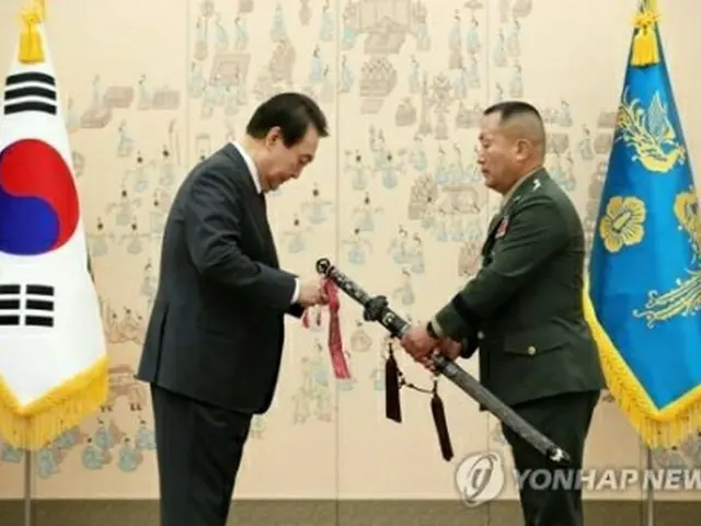 新海兵隊司令官の三精剣に布を付ける尹大統領（左、大統領通信写真記者団）＝７日、ソウル（聯合ニュース）