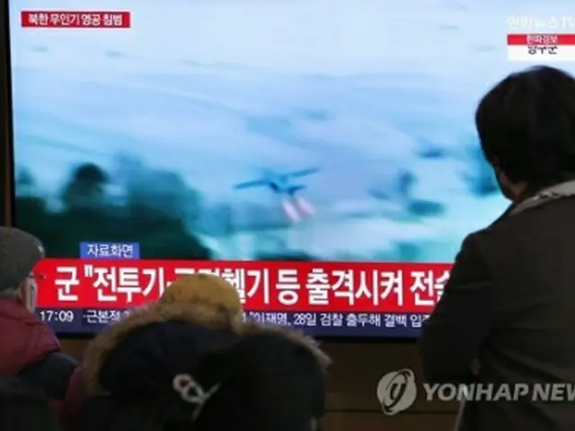 26日、ソウル駅のテレビで北朝鮮の無人機に関するニュースを見る人々＝（聯合ニュース）