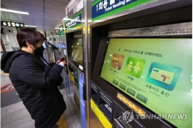 ソウル地下鉄1号線の市庁駅で地下鉄の切符を買う外国人観光客＝26日、ソウル（聯合ニュース）