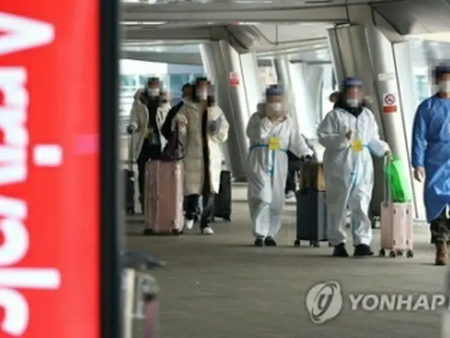 仁川空港の新型コロナ検査センターへ向かう中国からの入国者＝５日、仁川（聯合ニュース）