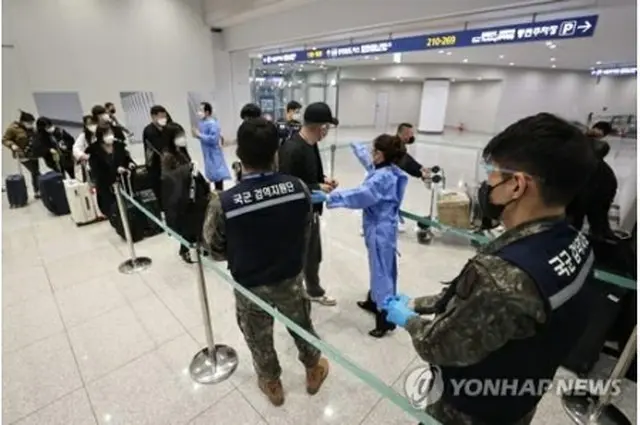 仁川国際空港の新型コロナ検査センターで順番を待つ中国からの入国者＝９日、仁川（聯合ニュース）