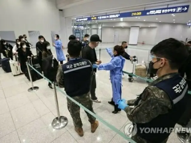 仁川国際空港の新型コロナ検査センターで順番を待つ中国からの入国者＝９日、仁川（聯合ニュース）