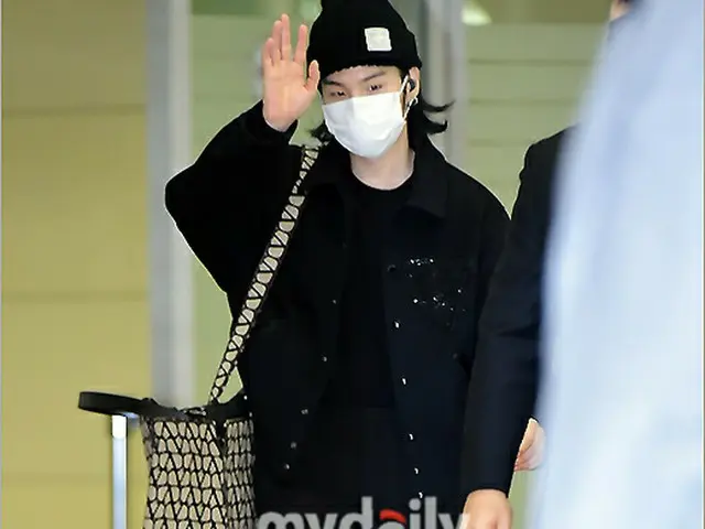 手を振ってあいさつをするSUGA。（画像提供:wowkorea）