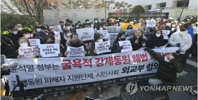 外交部前で徴用問題の解決案に抗議する市民団体メンバーら＝１８日、ソウル（聯合ニュース）