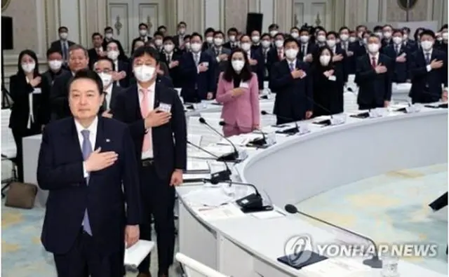 青瓦台（旧大統領府）の迎賓館で開かれた統一部などの業務報告で国旗に敬礼する尹大統領（先頭）ら＝27日、ソウル（聯合ニュース）