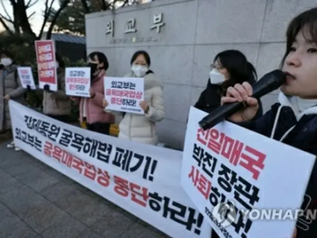 韓日の外交当局が協議を行っているソウルの外交部庁舎前で交渉の中止を求める集会を開く市民団体の関係者ら＝３０日、ソウル（聯合ニュース）