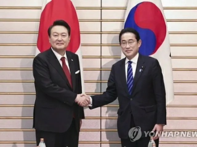 拡大会談前、握手を交わす尹大統領(左)と岸田首相=16日、東京(聯合ニュース)