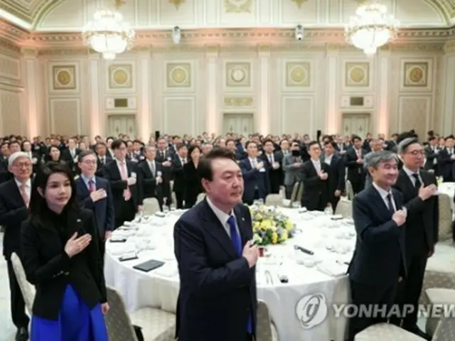 在外公館長との夕食会で国旗に敬礼する尹大統領（中央）ら＝27日、ソウル（聯合ニュース）