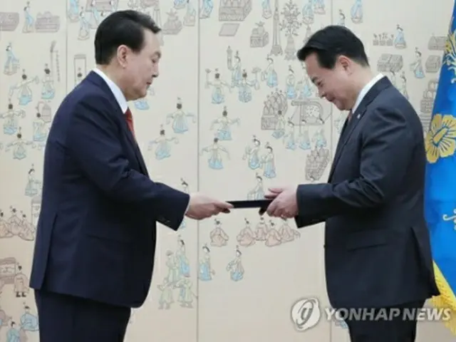 ソウル・竜山の大統領庁舎で趙駐米大使（右）に信任状を手渡す尹大統領（大統領室通信写真記者団）＝12日、ソウル（聯合ニュース）