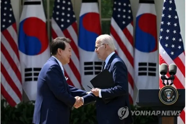 首脳会談後に開いた共同記者会見で握手を交わす尹大統領（左）とバイデン大統領＝２６日、ワシントン（聯合ニュース）