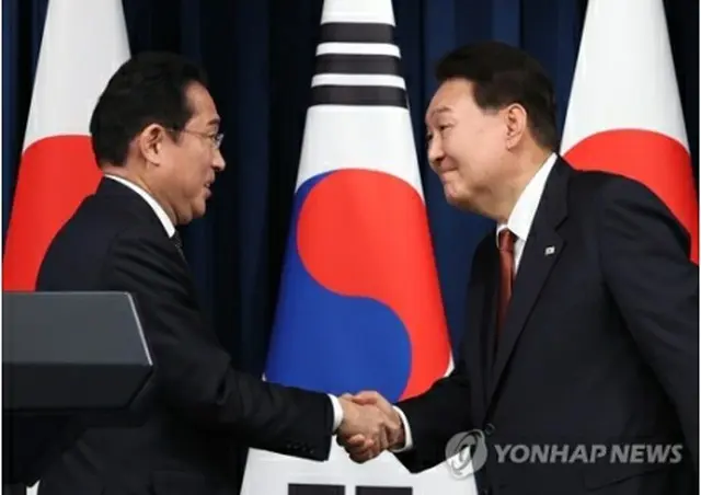 韓国の尹錫悦大統領（右）と日本の岸田文雄首相がソウルの大統領室で首脳会談を終え、共同記者会見を行った。会見終了後、笑顔で握手を交わす韓日首脳＝７日、ソウル（聯合ニュース）