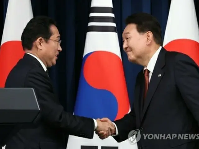 韓国の尹錫悦大統領（右）と日本の岸田文雄首相がソウルの大統領室で首脳会談を終え、共同記者会見を行った。会見終了後、笑顔で握手を交わす韓日首脳＝７日、ソウル（聯合ニュース）