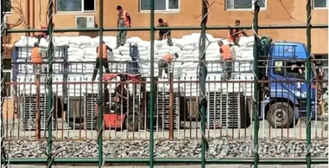 8日、中国・丹東で北朝鮮に送る物資を下ろす作業員＝（聯合ニュース）