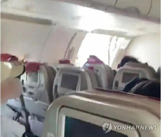 ドアが開いたまま飛行する旅客機（読者提供）＝（聯合ニュース）≪転載・転用禁止≫