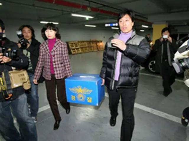 捜索を終え押収した資料を持ち出す警察関係者＝19日、ソウル（聯合）