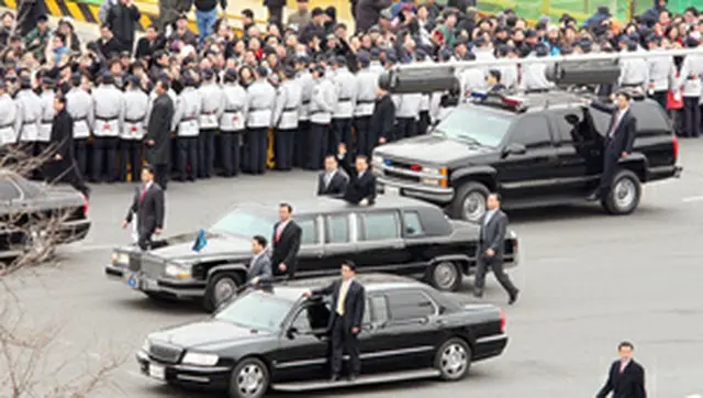 就任式を終え、手を振りながら式場を後にする李明博大統領＝25日、ソウル（聯合）