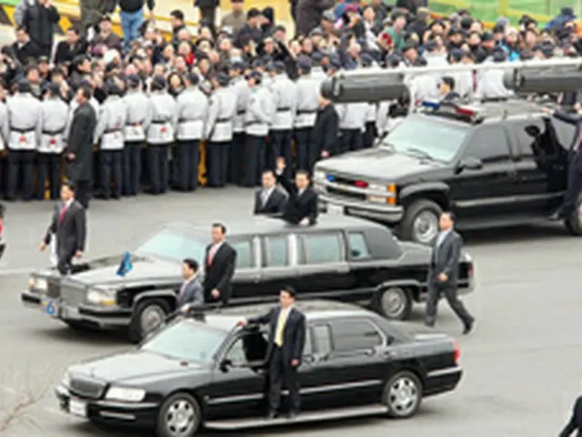 就任式を終え、手を振りながら式場を後にする李明博大統領＝25日、ソウル（聯合）