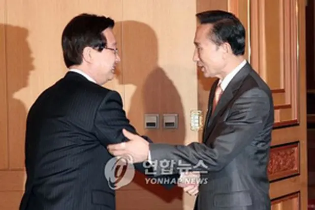 あいさつを交わす李大統領（右）と姜代表＝11日、ソウル（聯合）
