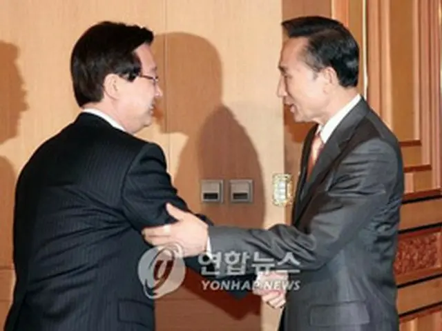 あいさつを交わす李大統領（右）と姜代表＝11日、ソウル（聯合）