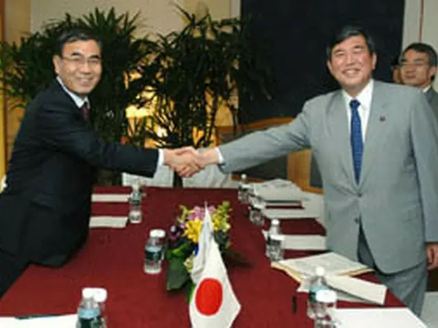 握手を交わす李長官（左）と石破防衛相（国防部提供）＝31日、ソウル（聯合）