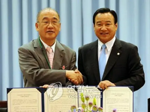 協定書を締結し握手を交わす両知事＝3日、大田（聯合）