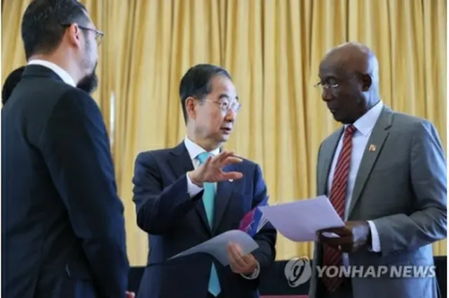 トリニダード・トバゴを訪れている韓首相（中央）。同国のローリー首相（右）と話を交わしている（国務総理室提供）＝（聯合ニュース）≪転載・転用禁止≫