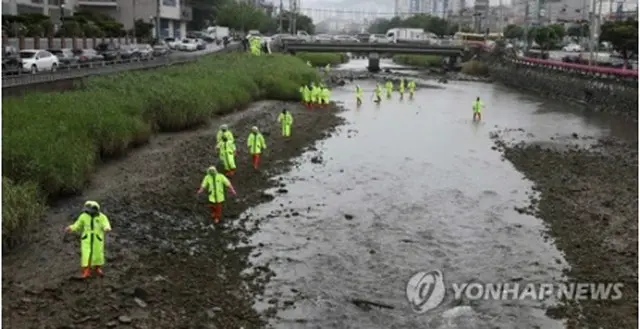 韓国南部の巨済市で起きたえい児の殺害遺棄事件で、遺体を捜索している警察関係者＝4日、巨済（聯合ニュース）