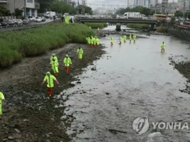 韓国南部の巨済市で起きたえい児の殺害遺棄事件で、遺体を捜索している警察関係者＝4日、巨済（聯合ニュース）
