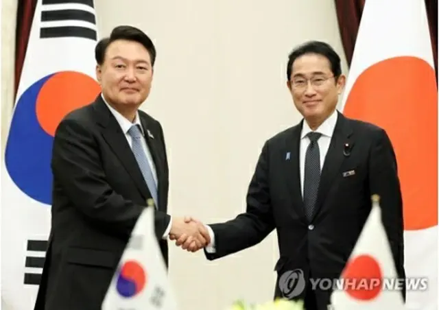 握手を交わす尹大統領と岸田首相＝１２日、ビリニュス（聯合ニュース）
