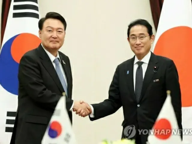 握手を交わす尹大統領と岸田首相＝１２日、ビリニュス（聯合ニュース）