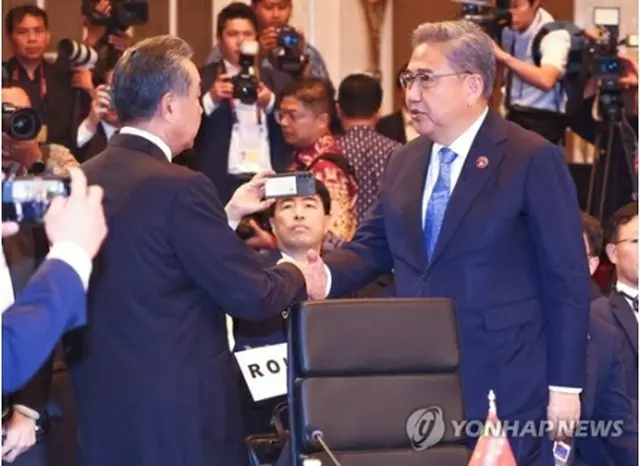ＡＳＥＡＮプラス３（韓中日）外相会議で握手する朴氏（右）と王氏＝１３日、ジャカルタ（聯合ニュース）