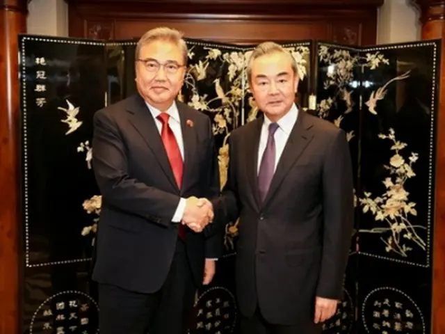 握手する朴氏（左）と王氏＝１４日、ジャカルタ（聯合ニュース）