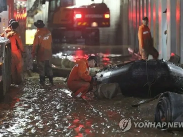近くの川の堤防流出により浸水した忠清北道・五松の地下道で、捜索作業が行われている＝１６日、清州（聯合ニュース）