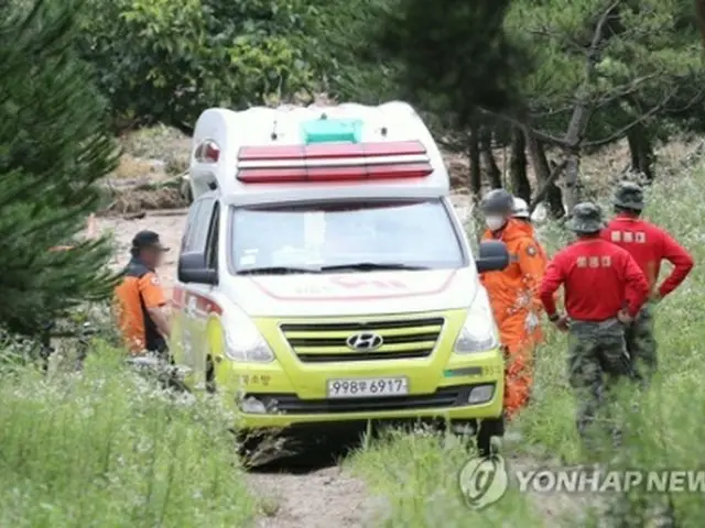 発見された行方不明者を搬送する救急隊員＝１８日、醴泉（聯合ニュース）