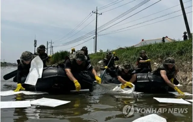 20日、西部の全羅北道益山市内で、河川に流出した油や浮遊物などを回収する陸軍将兵（陸軍第35歩兵師団提供）＝（聯合ニュース）≪転載・転用禁止≫