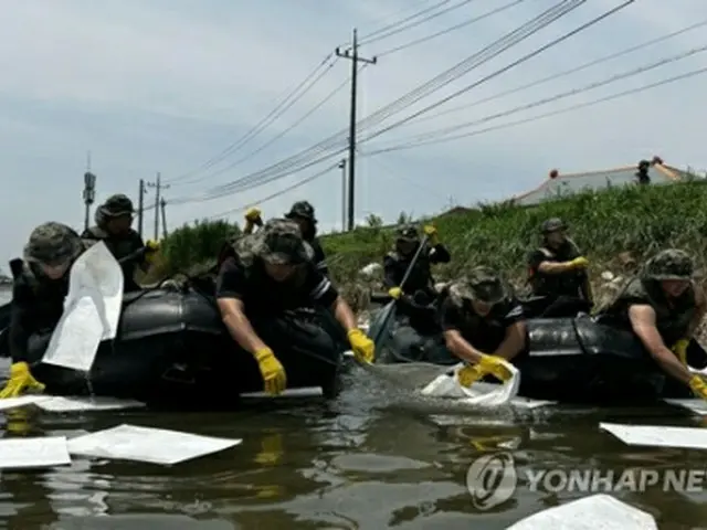 20日、西部の全羅北道益山市内で、河川に流出した油や浮遊物などを回収する陸軍将兵（陸軍第35歩兵師団提供）＝（聯合ニュース）≪転載・転用禁止≫
