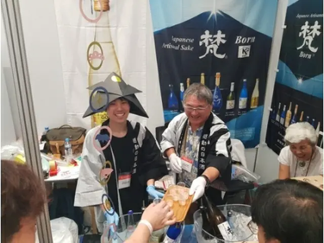来場客に酒を振る舞うイベント関係者＝２９日、ソウル（聯合ニュース）