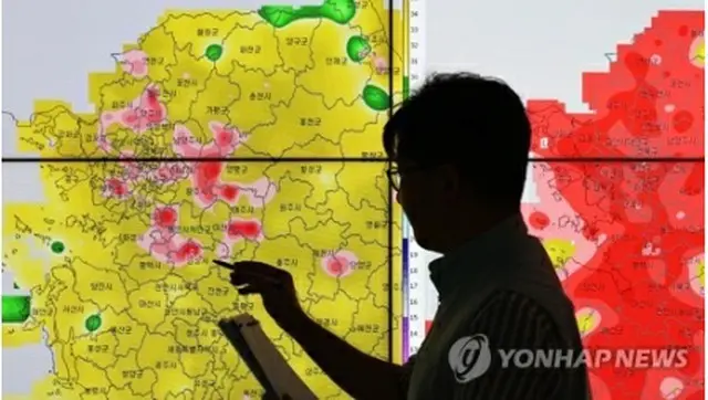 全国のほとんどの地域に猛暑警報・注意報が発令された３０日午後、ソウル郊外、京畿道水原市の首都圏気象庁で気象予報士が気温を確認している＝（聯合ニュース）