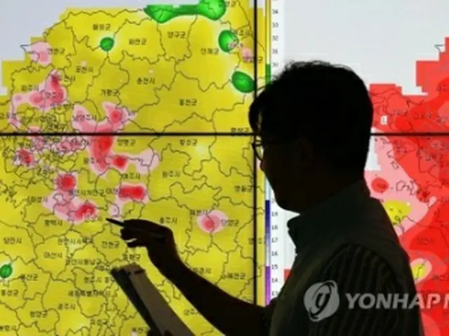 全国のほとんどの地域に猛暑警報・注意報が発令された３０日午後、ソウル郊外、京畿道水原市の首都圏気象庁で気象予報士が気温を確認している＝（聯合ニュース）