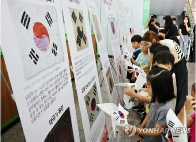 光復節を翌日に控えた１４日、光州市内の託児所で太極旗（韓国国旗）の風車で遊ぶ子どもたち＝１４日、光州（聯合ニュース）