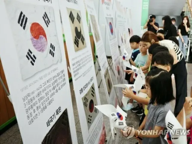 光復節を翌日に控えた１４日、光州市内の託児所で太極旗（韓国国旗）の風車で遊ぶ子どもたち＝１４日、光州（聯合ニュース）