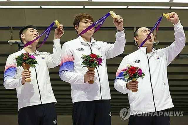 韓国は射撃男子１０メートルランニングターゲットミックス団体で金メダルを獲得した。表彰式で喜ぶ（左から）クァク・ヨンビン、チョン・ユジン、ハ・グァンチョル＝２６日、杭州（聯合ニュース）