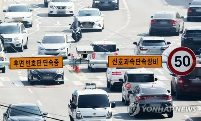 道路に設置された取り締まり装置。「後面ナンバープレート取り締まり中」と記されている（資料写真）＝（聯合ニュース）