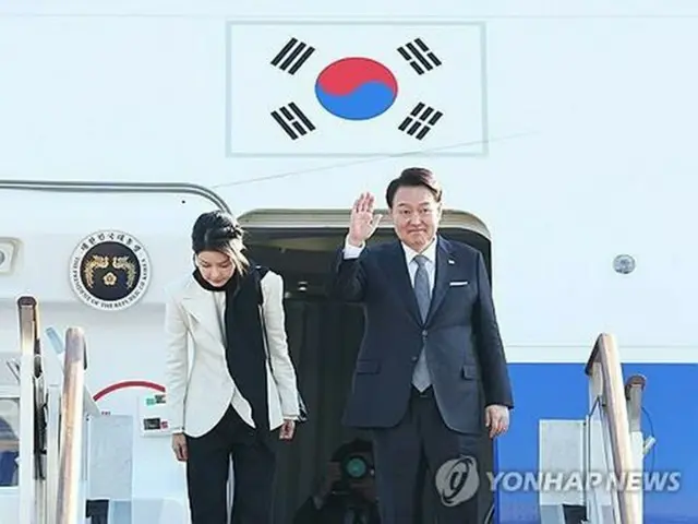 ソウル空港で大統領専用機の空軍１号機に乗り込む前、あいさつする尹大統領夫妻＝２０日、城南（聯合ニュース）