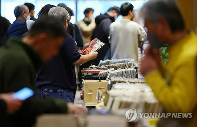 １２月上旬にソウルで開かれた「オーディオエキスポ２０２３」の会場でレコードを手に取る来場者（資料写真）＝（聯合ニュース）